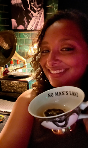 Woman smiling while holding a cup that says No Man's Land