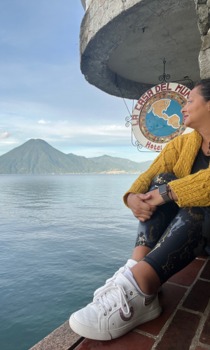 Woman wearing a yellow sweater on Lake Atitlan. Contemplating how men can make travel safer for women to solo travel the world.