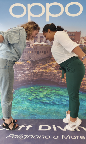 Two Solo Female travelers that met up in Polignano a Mare posing for a Cliff Diving Photo Opportunity. Dealing with Loneliness While Solo Traveling