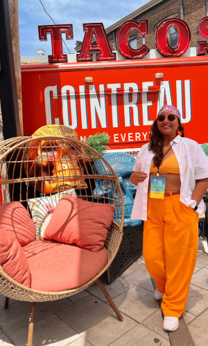 Woman, enjoying the outdoor patio dressed in orange and white.