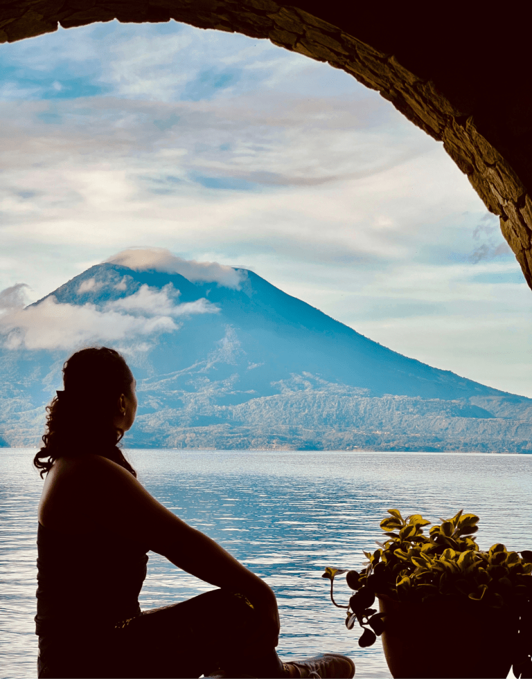 Woman sititng contemplating Lake Atitlan and the Volcano.