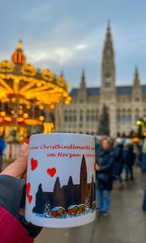 Ceramic Glühwein mug from the Vienna Christmas Market, featuring a festive design of the Rathaus (City Hall) and Christmas tree. Best European Christmas Markets