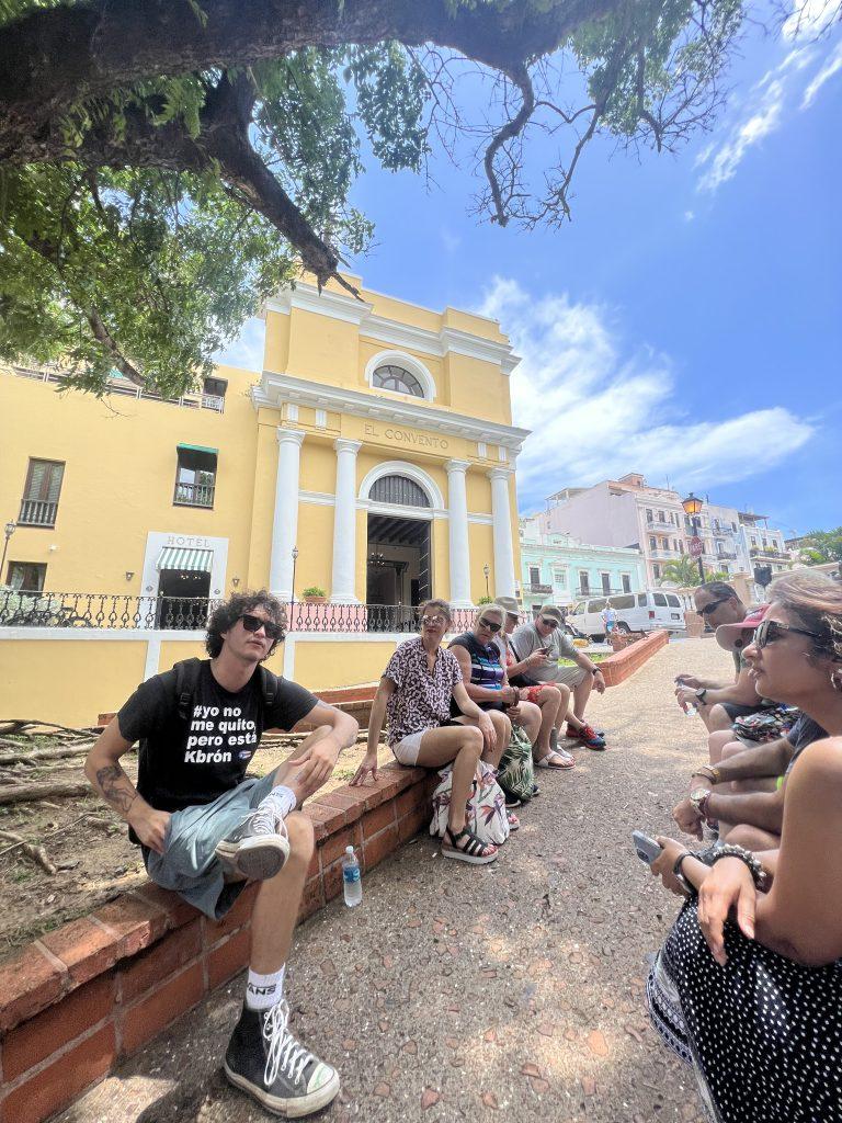 Tour group relaxing in front of Hotel El Convento in Old San Juan, Puerto Rico, during a cultural walking tour