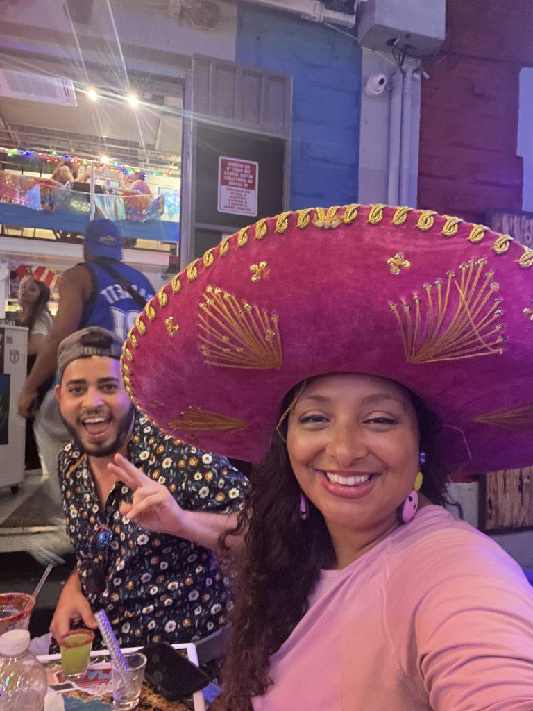 A Latina travel creator smiles with @travelcarlitosway at Sea Señor in La Placita de Santurce, Puerto Rico