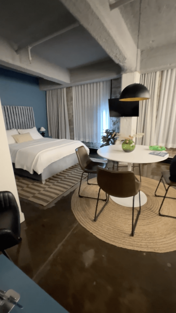 Studio-style apartment suite at Maison Sainte-Thérèse Montréal with bed, dining area, full kitchen and minimalist and modern decor, featured in The Queen of Trips guide on where to stay in Montréal 2026.